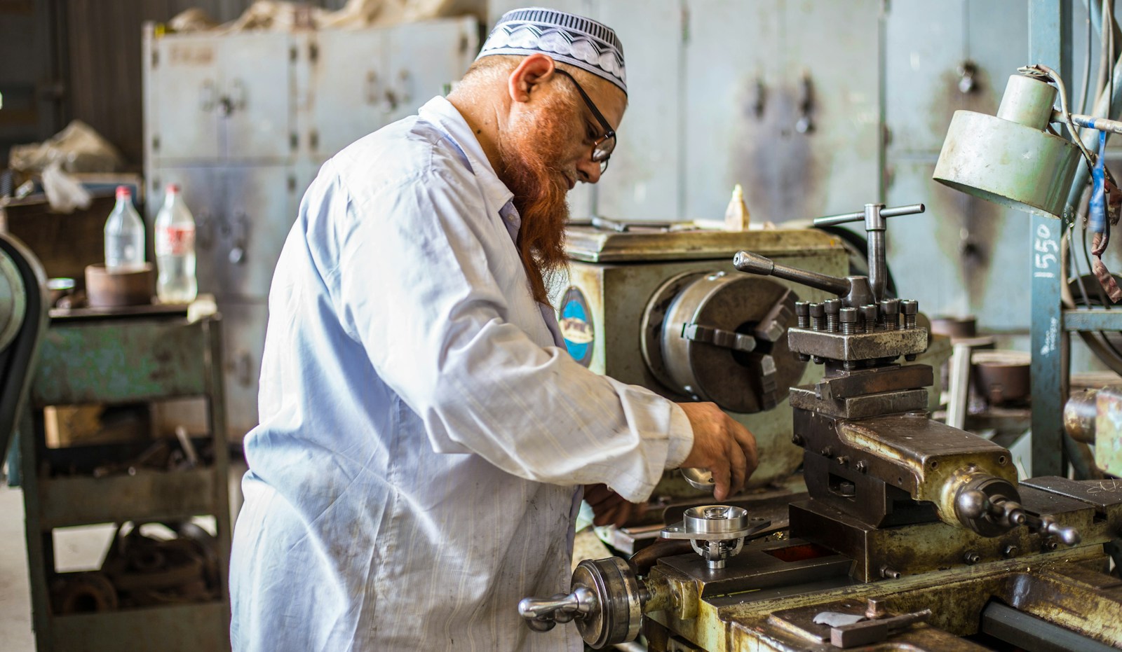 A person operating industrial equipment in a workshop