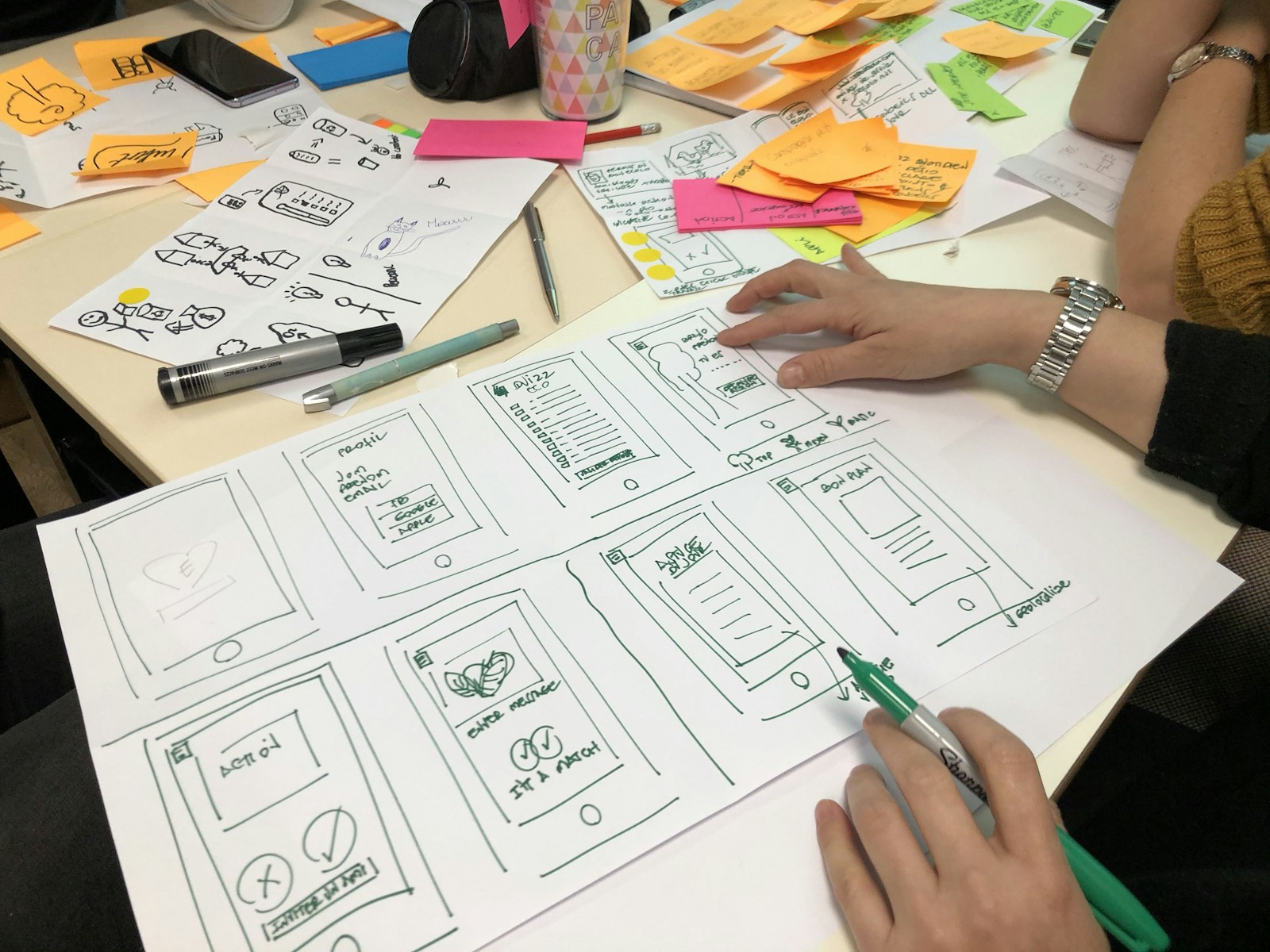 Hands arranging notes and planning material on a work table